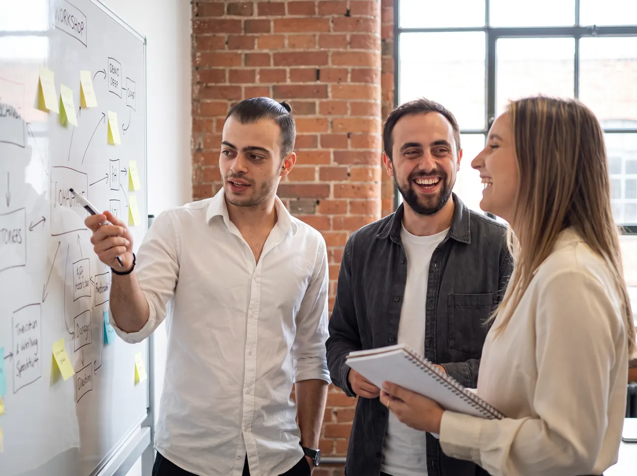 Michael with two of the team working through a plan at the whiteboard