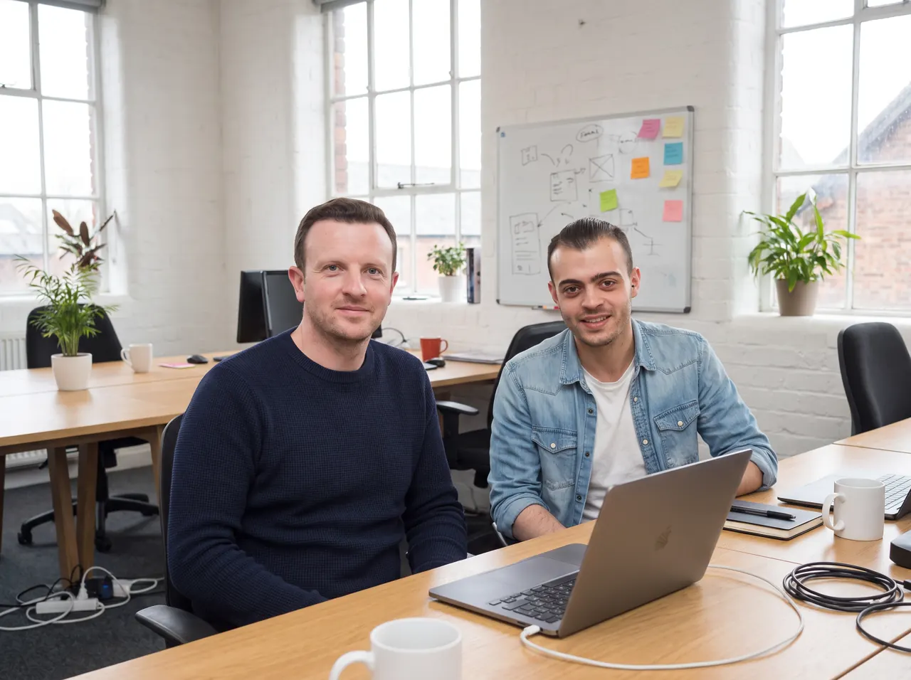 Simon and Michael at their desks in the office